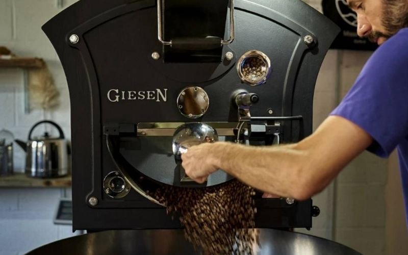 A roaster releasing freshly roasted coffee beans from a Giesen roaster at Missing Bean