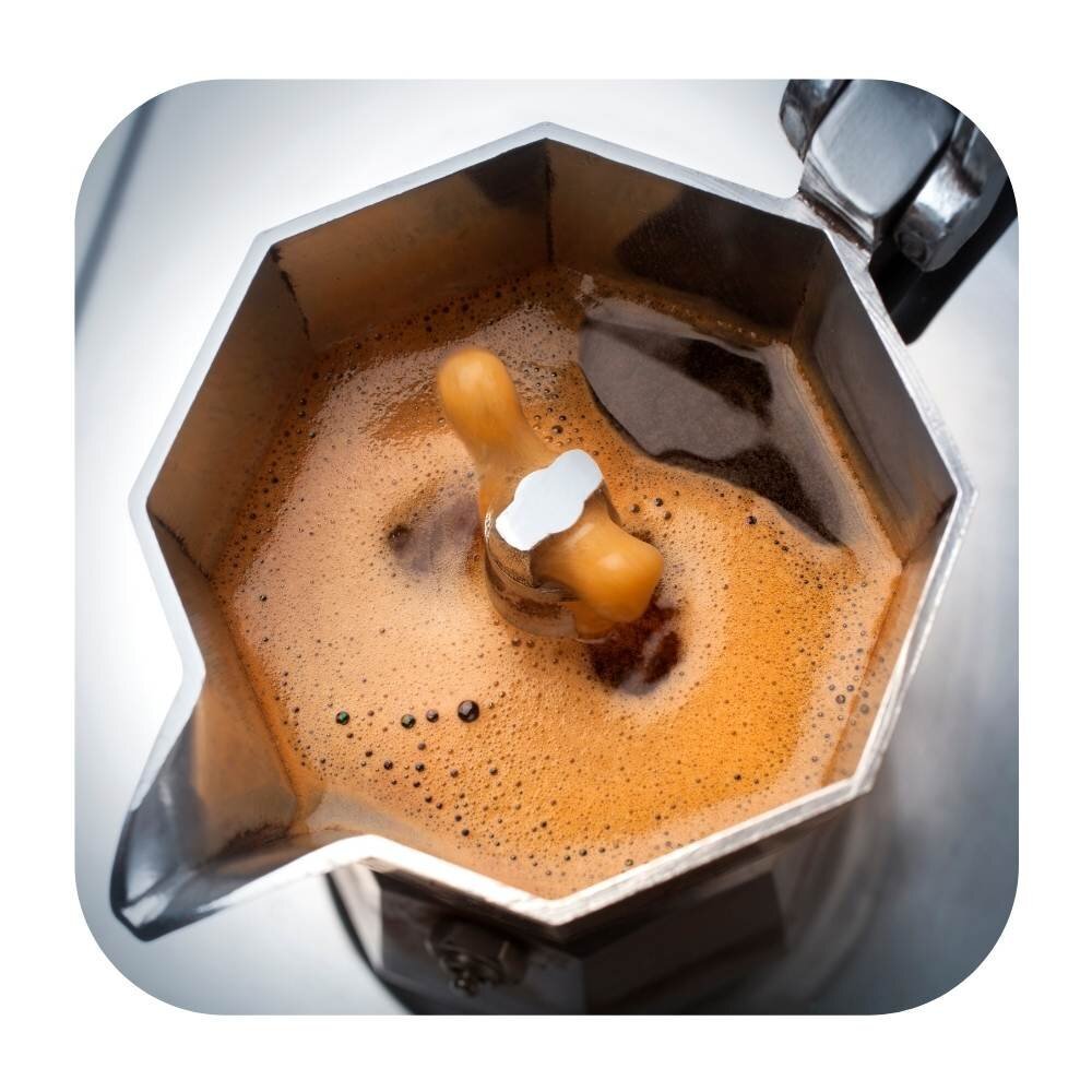 Coffee brewing up through the spout of a moka pot
