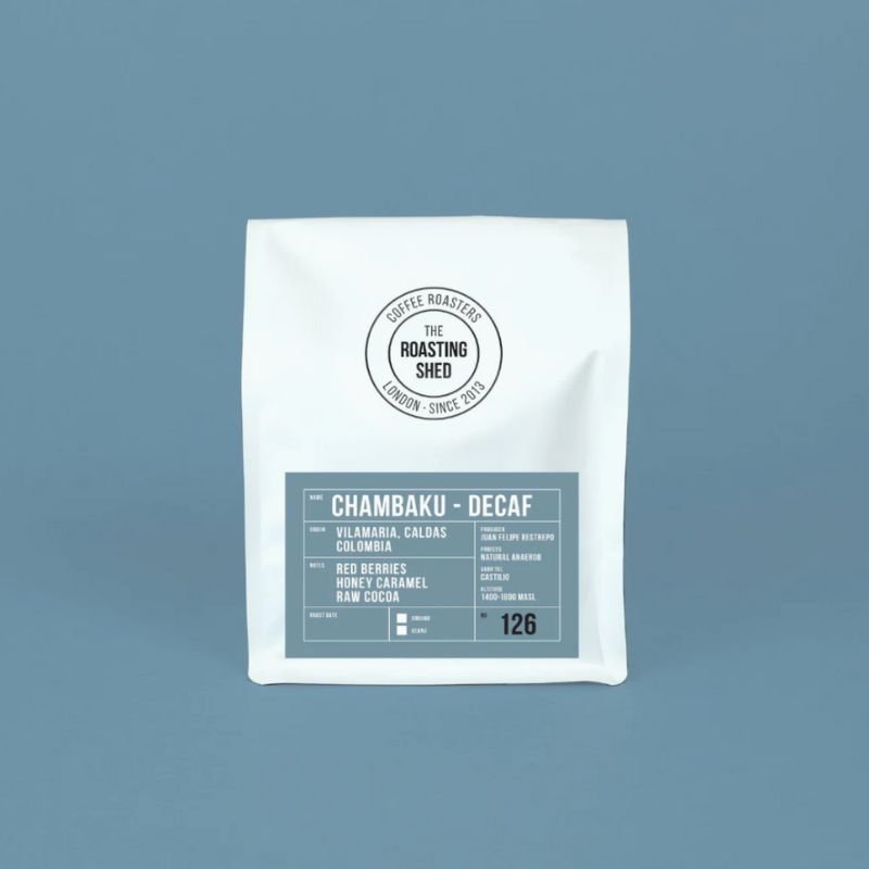 A white bag of Chambaku decaf from The Roasting Shed on a blue background