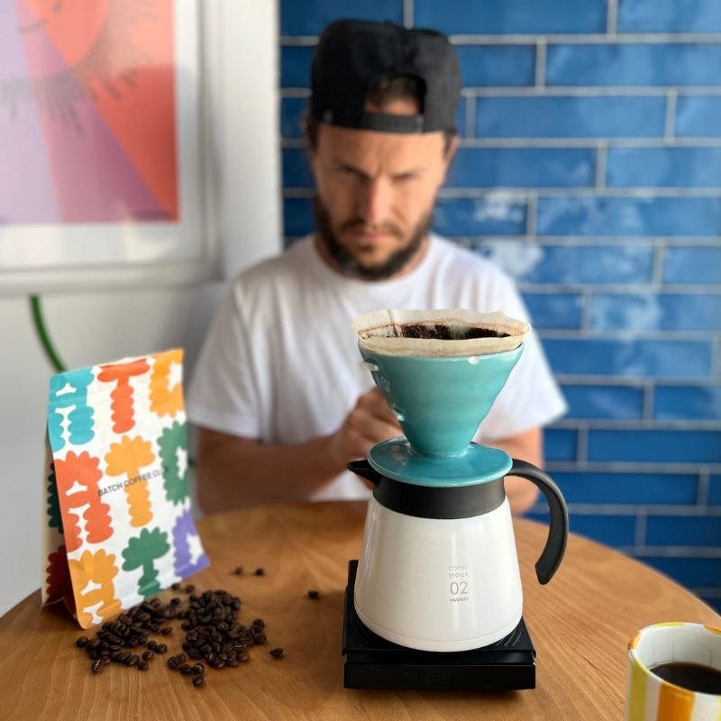 Tom preparing coffee using a white Hario V60 dripper