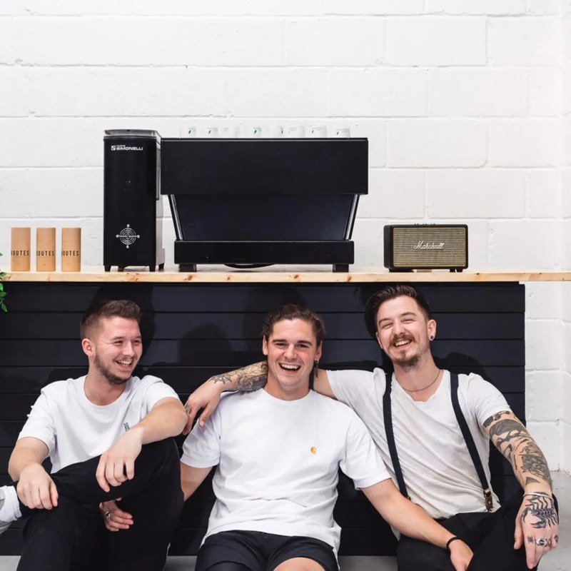 The Routes Coffee Roasters team sitting in front of their espresso machine